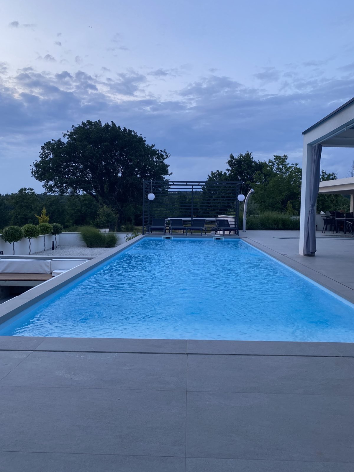 Large private swimming pool with sun loungers and landscaped garden